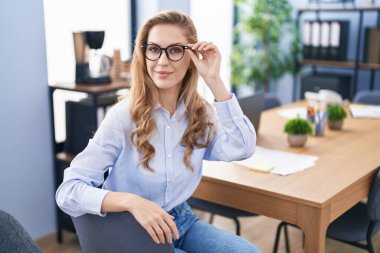 Genç sarışın iş kadını ofiste kendine güvenen gülümseyen