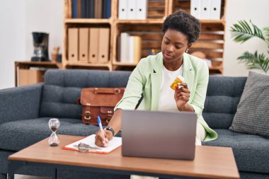 Psikoloji merkezinde telekonksiyon reçetesi yazan Afrikalı Amerikalı kadın psikolog.