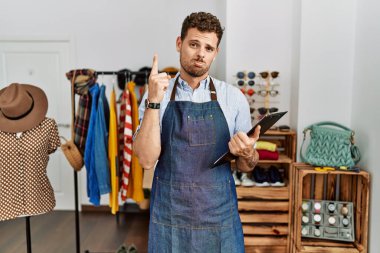 Perakende mağazasında yönetici olarak çalışan yakışıklı genç adam üzgün ve üzgün görünüyor, parmaklarıyla yönü gösteriyor, mutsuz ve depresif.. 