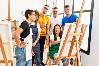 Mutlu gülümseyen ve ortak arayan bir grup insan sanat stüdyosunda..