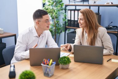 Man and woman business workers using laptop working at office