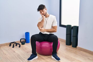 Sakallı İspanyol bir adam yoga odasında pilatese oturmuş kollarını kavuşturup depresyondan sıkılmış ve yorgun göründüğünü sanıyor.. 