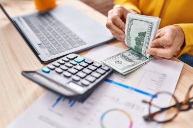 Genç kadın ecommerce iş işçisi ofiste dolar sayıyor