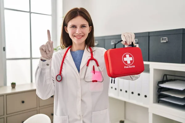 Молода Лікарка Тримає Аптечку Посміхається Ідеєю Або Питанням Вказуючи Пальцем — стокове фото