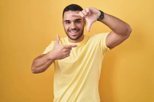 Homem Hispânico Jovem Sobre Fundo Amarelo Sorrindo Fazendo Quadro Com — Fotografia de Stock