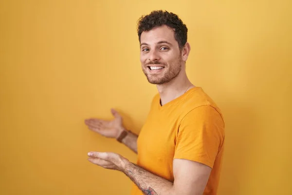 Joven Hispano Pie Sobre Fondo Amarillo Invitando Entrar Sonriente Natural —  Fotos de Stock