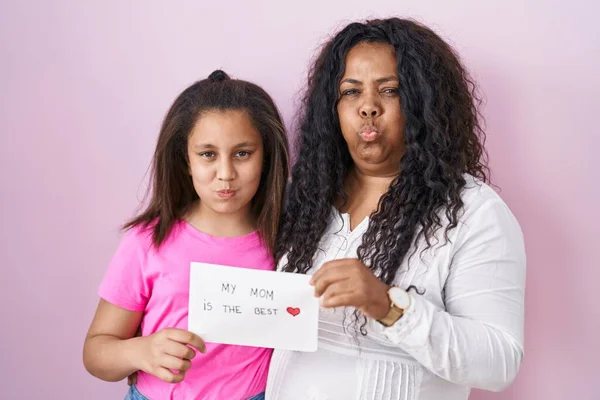 Madre Hija Pequeña Sosteniendo Madre Mejor Pancarta Soplando Mejillas Con —  Fotos de Stock