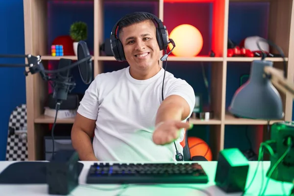 若いヒスパニック系の男がビデオゲームをプレイ笑顔陽気な提供ヤシの手援助と受け入れ — ストック写真