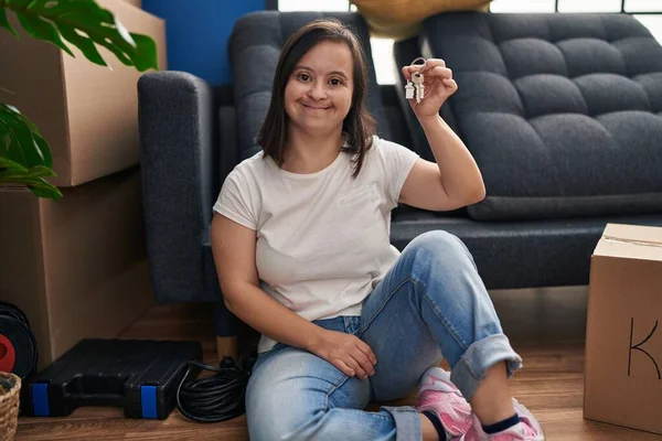 Syndrome Woman Smiling Confident Holding Key Sitting Floor New Home — Zdjęcie stockowe