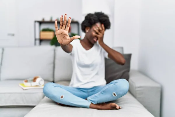 Afrikaanse Jonge Vrouw Zit Bank Thuis Bedekken Ogen Met Handen — Stockfoto