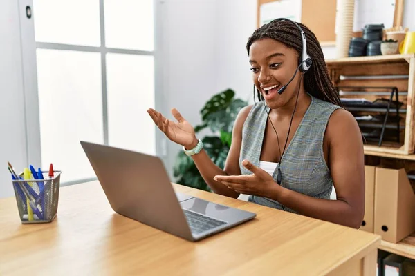 Young african american woman call center agent having video call at office