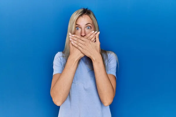 Hermosa Mujer Rubia Con Camiseta Casual Sobre Fondo Azul Impactada — Foto de Stock