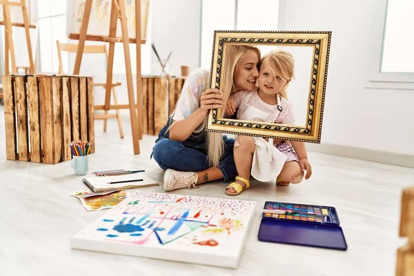 Mother Daughter Smiling Confident Holding Empty Frame Sitting Floor Art — 图库照片