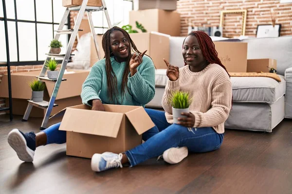 Twee Afrikaanse Vrouwen Verhuizen Naar Een Nieuw Huis Vloer Glimlachend — Stockfoto