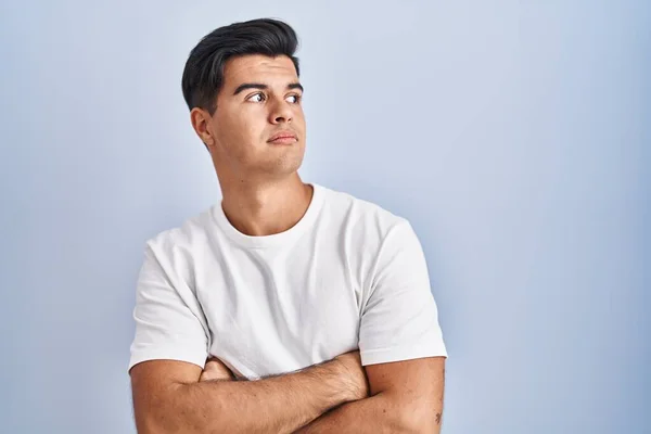 Hispanic Man Standing Blue Background Looking Side Arms Crossed Convinced — Zdjęcie stockowe