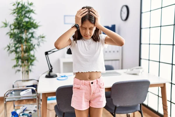 Pediatri kliniğinde dikilen genç İspanyol kız baş ağrısı çekiyor. Ağrı ve migren yüzünden çaresiz ve stresli. Eller başının üstünde.. 