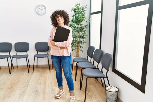 Young Middle East Woman Smiling Confident Holding Clipboard Waiting Room — Stockfoto
