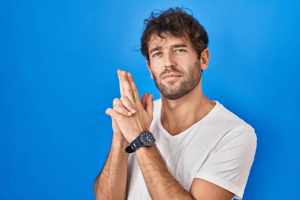 Hispanic Ung Man Står Över Blå Bakgrund Innehar Symbolisk Pistol — Stockfoto