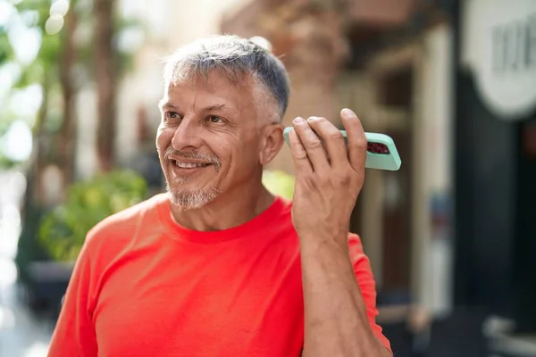Hombre Pelo Gris Mediana Edad Sonriendo Confiado Escuchando Mensaje Audio — Foto de Stock
