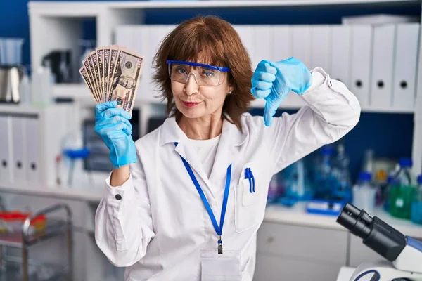 Женщина Средних Лет Работающая Научной Лаборатории Держит Деньги Разгневанным Лицом — стоковое фото