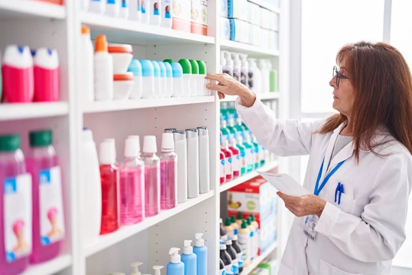 Middle Age Woman Pharmacist Holding Bottle Reading Prescription Pharmacy — Stockfoto