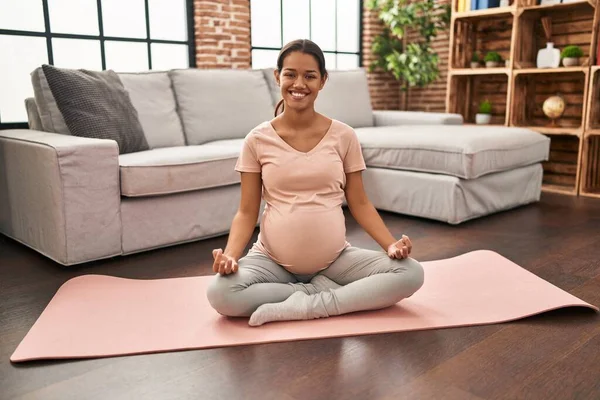 年轻的拉丁裔孕妇在家里笑着自信地训练瑜伽 — 图库照片