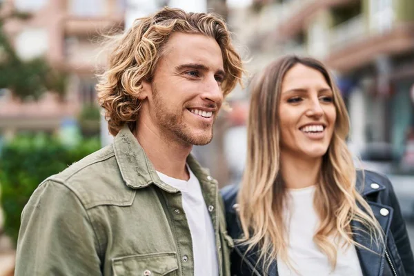 Erkek ve kadın bir arada durarak gülümsüyor.