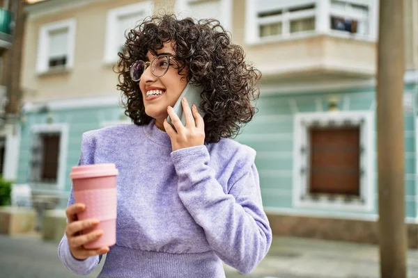 若い中東の女性は路上でスマートフォンで自信を持って話して笑顔 — ストック写真