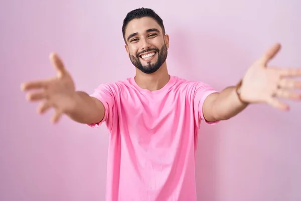 Hispanic Ung Man Står Över Rosa Bakgrund Tittar Kameran Ler — Stockfoto