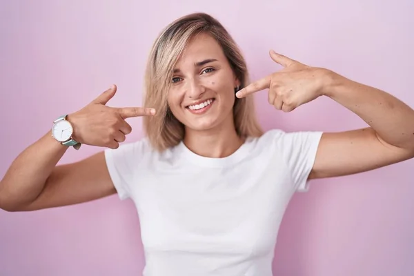 Pembe Arka Planda Duran Genç Sarışın Kadın Neşeli Bir Şekilde — Stok fotoğraf