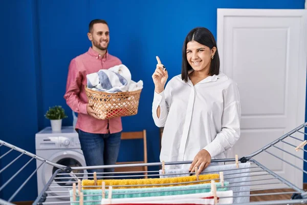 Casal Jovem Pendurado Roupas Varal Sorrindo Feliz Apontando Com Mão — Fotografia de Stock