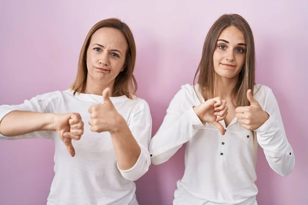Middle Age Mother Young Daughter Standing Pink Background Doing Thumbs — Stockfoto