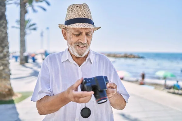 Senior Man Smiling Confident Wearing Summer Hat Using Camera Seaside — Stock Photo, Image
