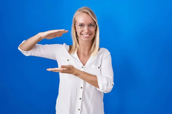 Jonge Blanke Vrouw Staat Blauwe Achtergrond Gebaren Met Handen Tonen — Stockfoto