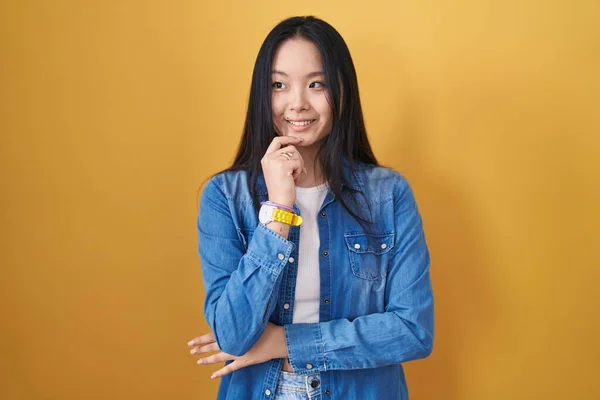 Junge Asiatin Die Vor Gelbem Hintergrund Steht Die Hand Kinn — Stockfoto