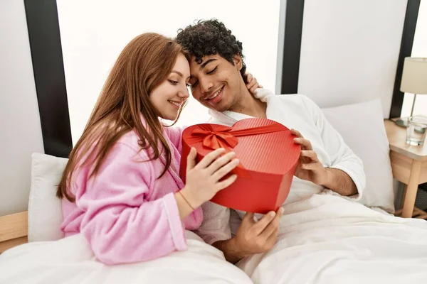 Young Couple Smiling Happy Holding Valentine Heart Box Gift Bedroom — Stok fotoğraf