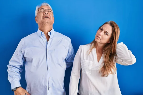 Middle Age Hispanic Couple Standing Blue Background Suffering Neck Ache — Stock Photo, Image