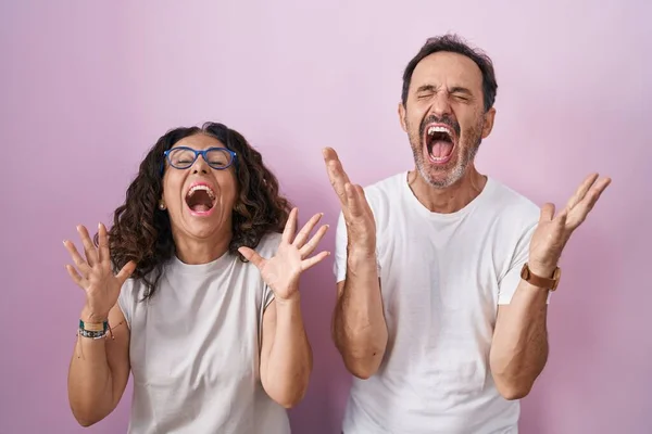 Középkorú Spanyol Házaspár Együtt Rózsaszín Háttér Ünnepli Őrült Őrült Siker — Stock Fotó