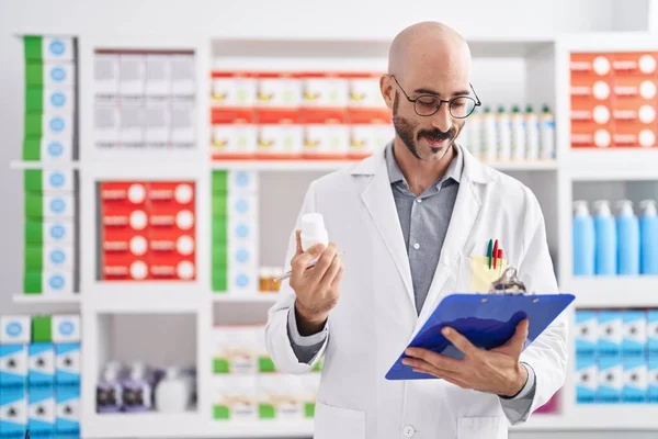 Young Hispanic Man Pharmacist Holding Clipboard Pills Pharmacy — Stockfoto