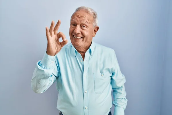 Hombre Mayor Con Pelo Gris Pie Sobre Fondo Azul Sonriendo —  Fotos de Stock