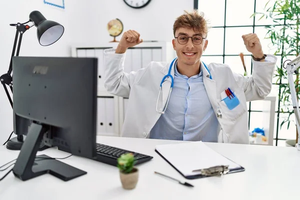 Young Caucasian Doctor Man Working Clinic Showing Arms Muscles Smiling — Stok fotoğraf