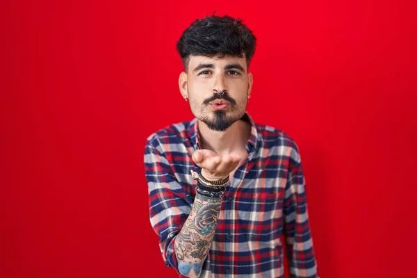 Jovem Hispânico Com Barba Sobre Fundo Vermelho Olhando Para Câmera — Fotografia de Stock