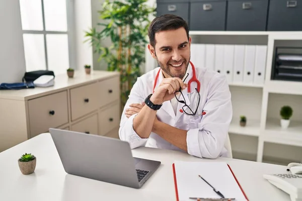 Joven Hispano Vistiendo Uniforme Médico Usando Laptop Trabajando Clínica — Foto de Stock