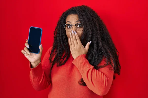 Size Hispanic Woman Holding Smartphone Showing Blank Screen Covering Mouth — 图库照片