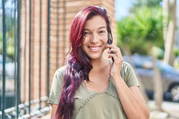 若い美しいですヒスパニック女性笑顔自信を持って話して上のスマートフォンで通り — ストック写真