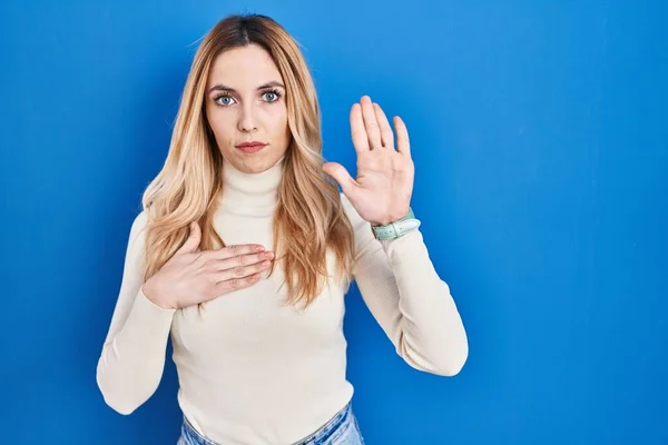 Young Caucasian Woman Standing Blue Background Swearing Hand Chest Open — Stockfoto