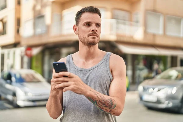 Jovem Hispânico Usando Smartphone Com Expressão Séria Rua — Fotografia de Stock