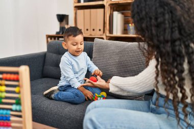 Mother and son having educational therapy at pedagogue center
