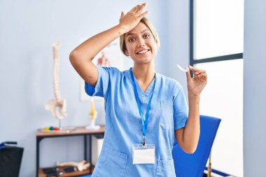 Sarışın genç bir kadın elinde Bruxizm için plastik bir hizalama tutuyordu. Elleri havada, şaşırmış ve sinirli bir yüz ifadesi vardı. 