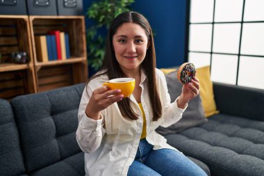 Genç İspanyol kadın evde kahvaltı ederken kendine güler yüzlü.